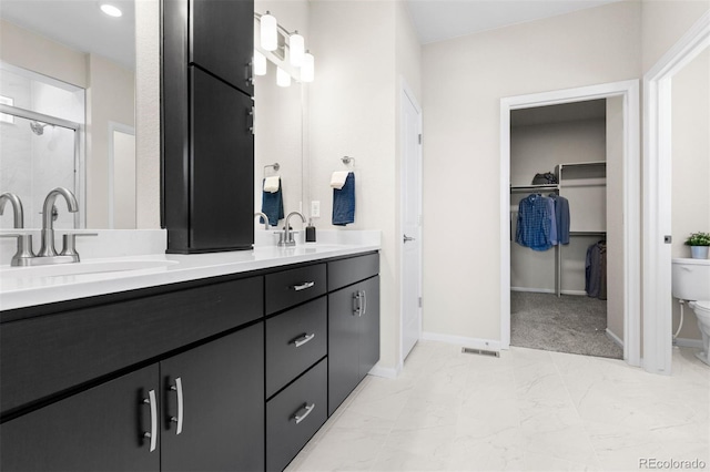 22374 E 49th Pl, Aurora, CO 80019 - full bath with double vanity, marble finish flooring, a shower stall, and a walk in closet