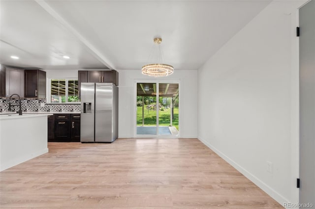 13010 W 6th Pl, Golden, CO 80401 - kitchen with stainless steel fridge, a chandelier, dark brown cabinets, light countertops, and light wood-style floors