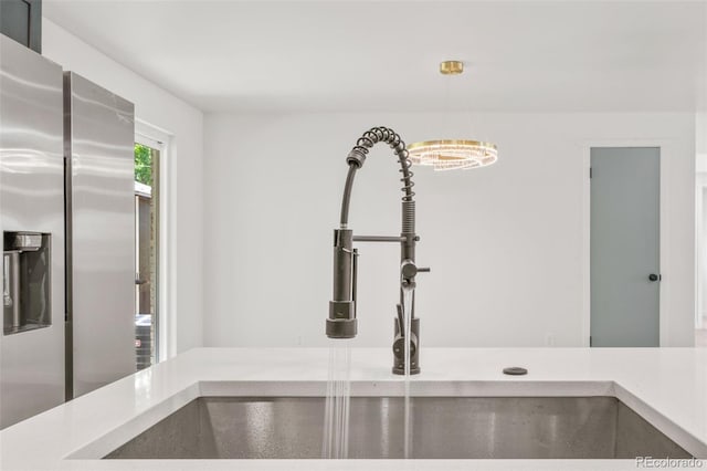 13010 W 6th Pl, Golden, CO 80401 - kitchen view of stainless steel fridge with ice dispenser, a sink, light countertops, and pendant lighting