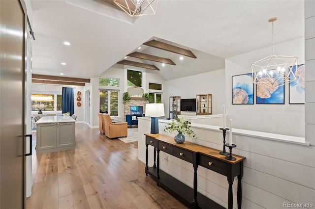 corridor with lofted ceiling with beams, a notable chandelier, recessed lighting, and light wood finished floors