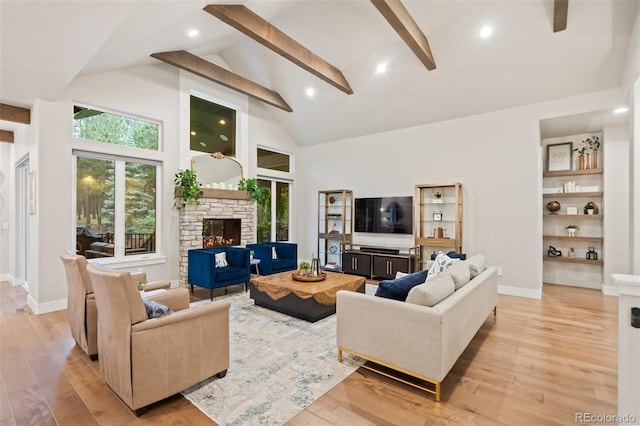 living area featuring beamed ceiling, a fireplace, high vaulted ceiling, and light wood-type flooring