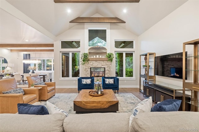 living room featuring beam ceiling, a fireplace, high vaulted ceiling, and wood finished floors