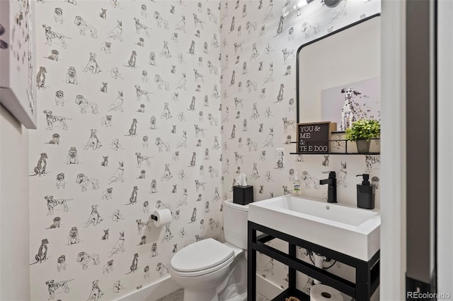 bathroom with toilet and wallpapered walls