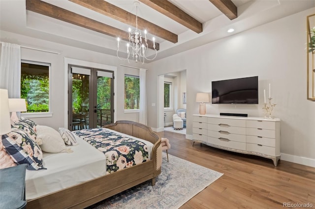 bedroom with access to outside, multiple windows, wood finished floors, and french doors