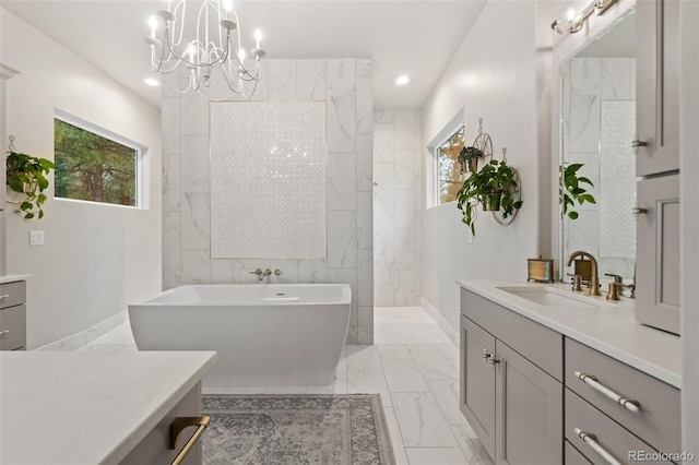 bathroom with vanity, a soaking tub, plenty of natural light, and marble finish floor