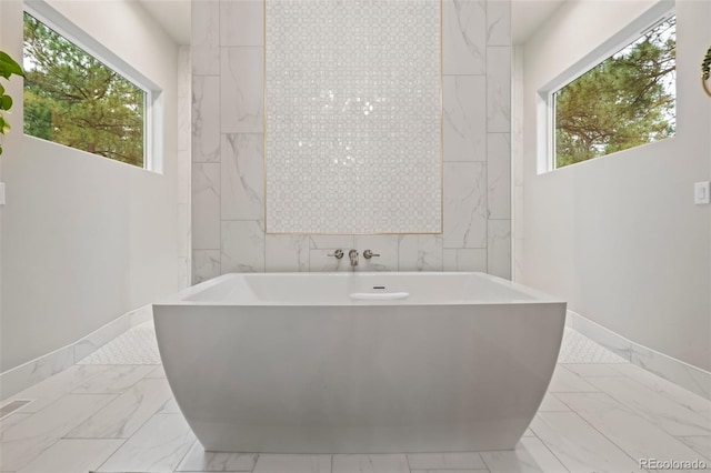 bathroom with tile walls and a bath