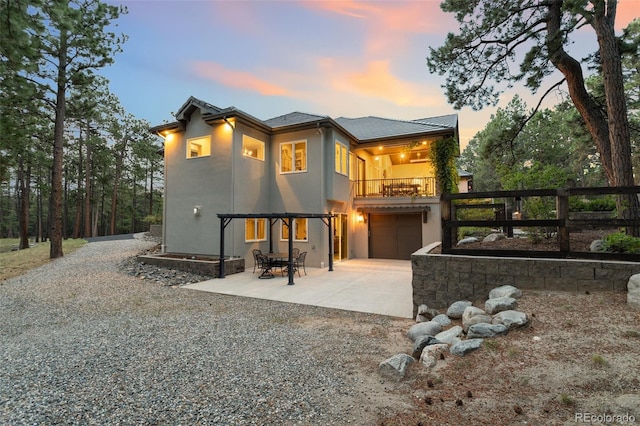 back house at dusk with a patio