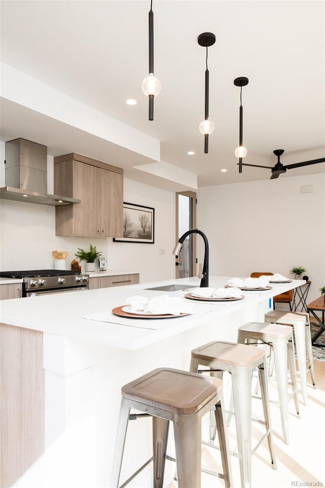 3433 Lawrence St Unit 1, Denver, CO 80205 - kitchen with wall chimney range hood, a sink, a breakfast bar, modern cabinets, and light countertops