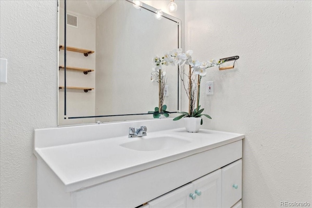 bathroom with vanity and a textured wall