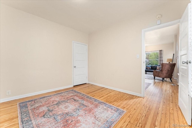unfurnished room with light wood-style flooring and baseboards