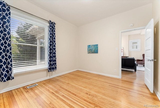 spare room with light wood-style flooring and baseboards