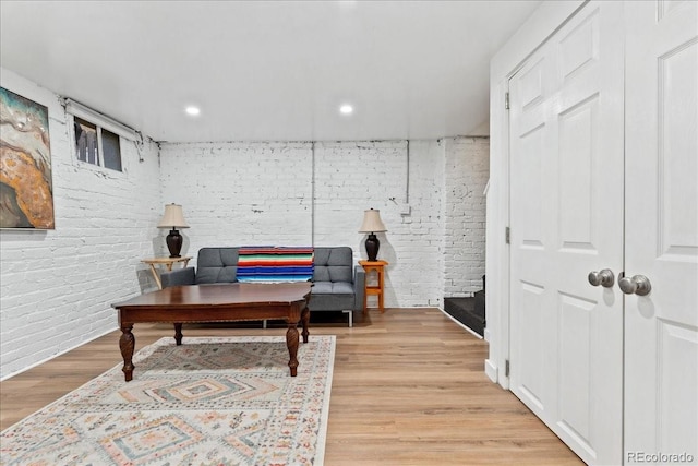 office space featuring brick wall, light wood finished floors, and recessed lighting