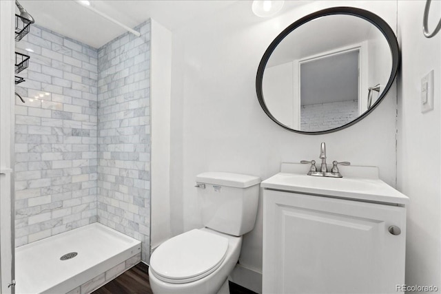 bathroom featuring a shower stall, toilet, vanity, and wood finished floors