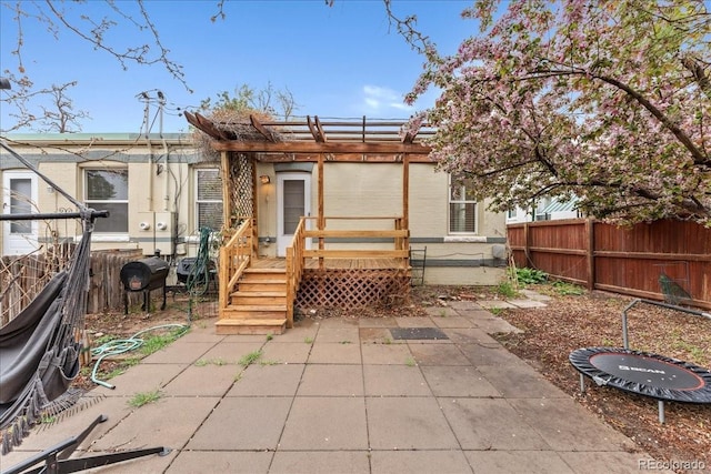 back of house featuring fence, a wooden deck, a pergola, and a patio area
