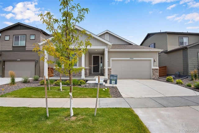 13351 E 100th Pl, Commerce City, CO 80022 - craftsman-style house with an attached garage, stone siding, a porch, a front yard, and concrete driveway