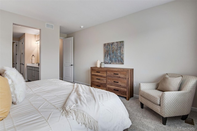 bedroom featuring ensuite bath and light colored carpet