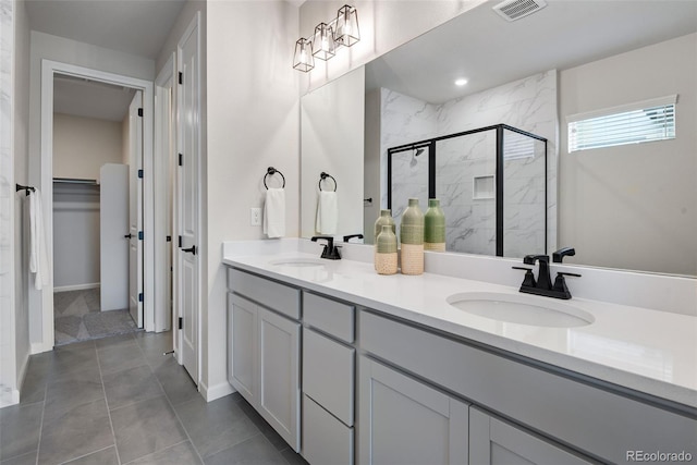 bathroom with vanity, a shower with shower door, and tile patterned flooring