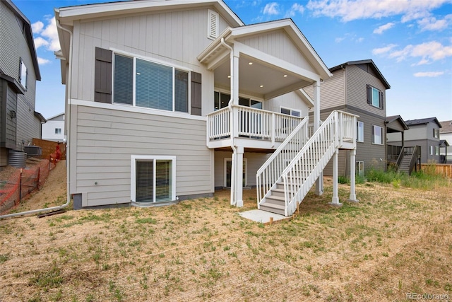 back of house featuring a wooden deck and a lawn