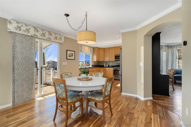 dining room with sink, ornamental molding, and light hardwood / wood-style flooring