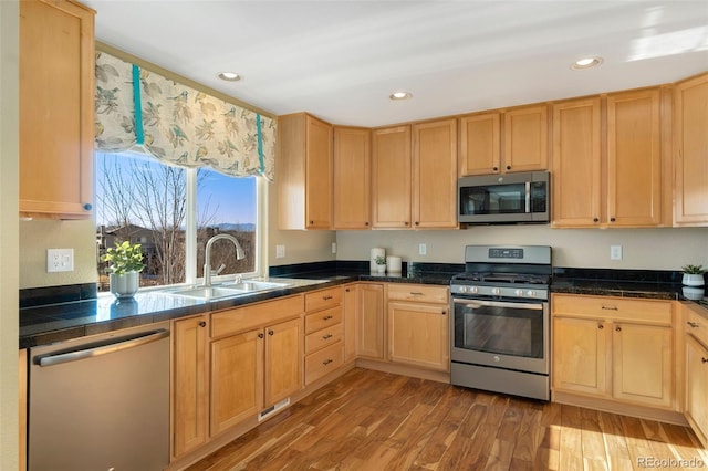 kitchen with light wood-type flooring, sink, light brown cabinets, and stainless steel appliances