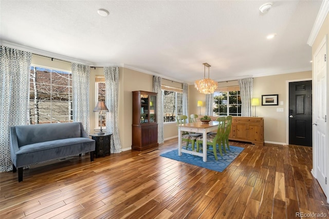 dining area featuring an inviting chandelier, ornamental molding, and hardwood / wood-style floors