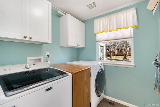 clothes washing area with cabinets and independent washer and dryer