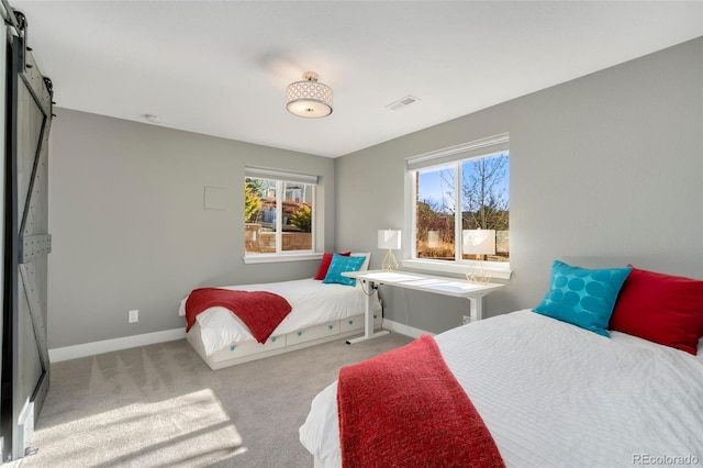 carpeted bedroom featuring a barn door