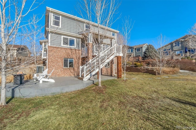 rear view of property with a lawn and a patio