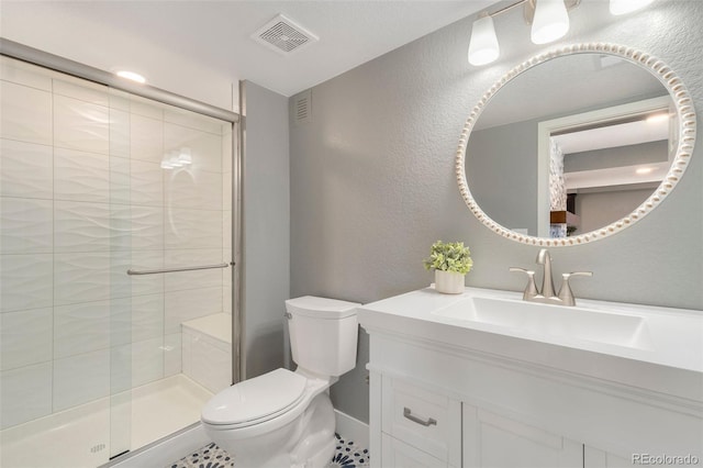 bathroom featuring toilet, vanity, tile patterned flooring, and walk in shower