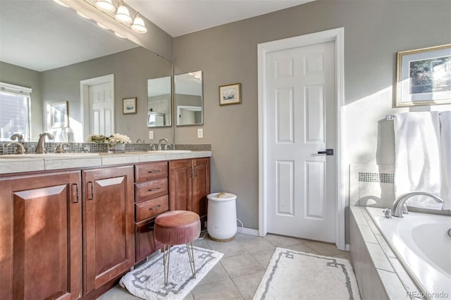 bathroom featuring tile patterned flooring, a relaxing tiled tub, and vanity