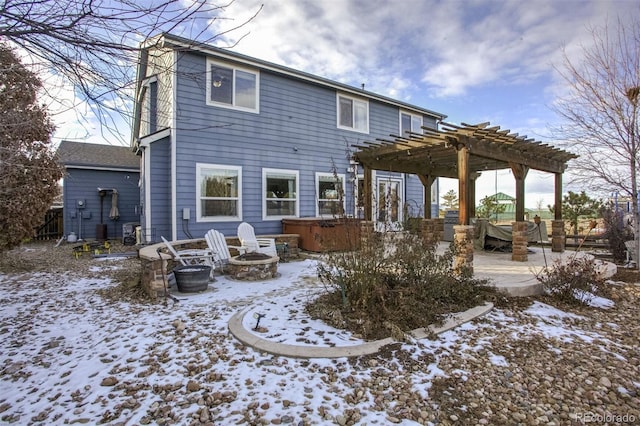 snow covered property with a fire pit, a hot tub, a pergola, and a patio area