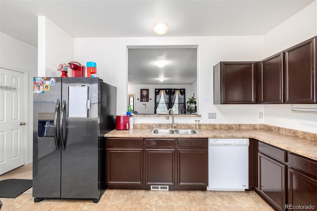 kitchen featuring dishwasher, sink, dark brown cabinets, and stainless steel fridge