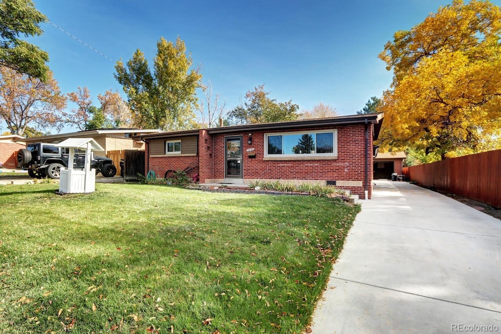 ranch-style house featuring a carport and a front lawn