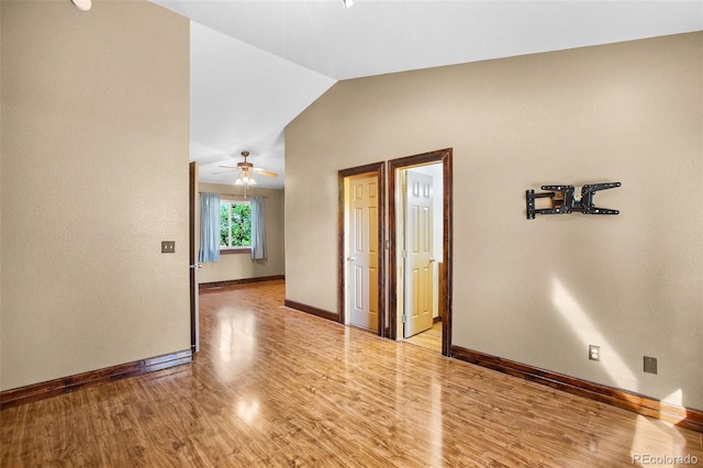 empty room featuring ceiling fan, light hardwood / wood-style floors, and vaulted ceiling