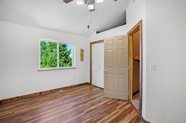 unfurnished bedroom with lofted ceiling, ceiling fan, and dark hardwood / wood-style floors