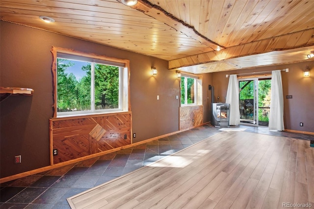 interior space with wood ceiling, hardwood / wood-style floors, beamed ceiling, and a wood stove