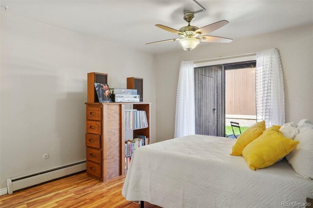 bedroom with ceiling fan, baseboard heating, and light hardwood / wood-style floors