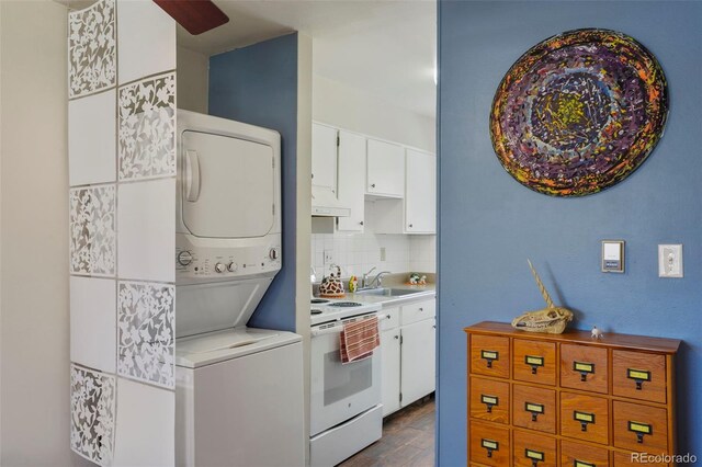 kitchen featuring light countertops, white cabinetry, white electric range oven, and stacked washer / drying machine