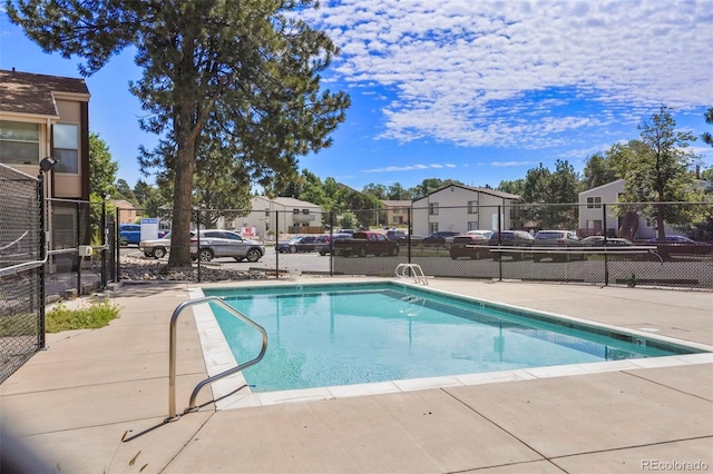 community pool featuring a residential view and fence