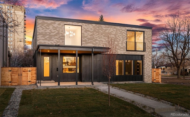 back house at dusk featuring a yard