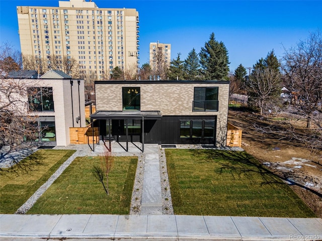 rear view of house with a patio and a lawn