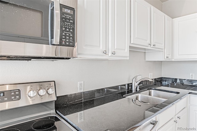 kitchen featuring stainless steel appliances, sink, and white cabinets