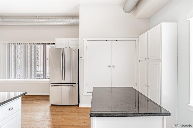 kitchen featuring white cabinets, stainless steel fridge, and light wood-type flooring