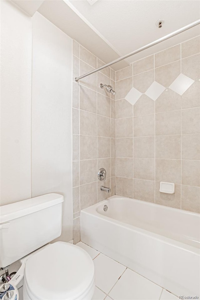 bathroom with toilet, tiled shower / bath combo, and tile patterned flooring