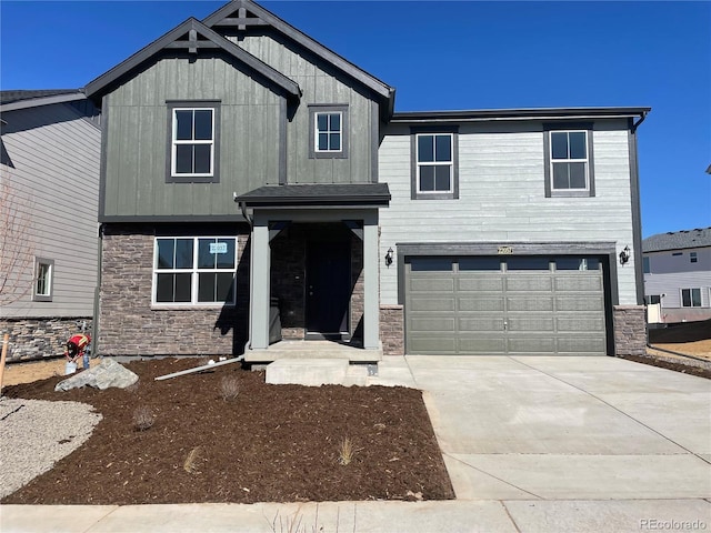 view of front of property featuring concrete driveway, an attached garage, and stone siding