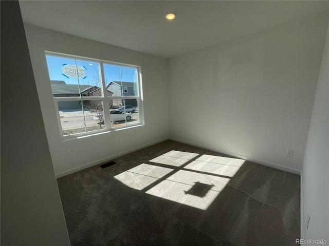 spare room with visible vents, baseboards, and carpet flooring