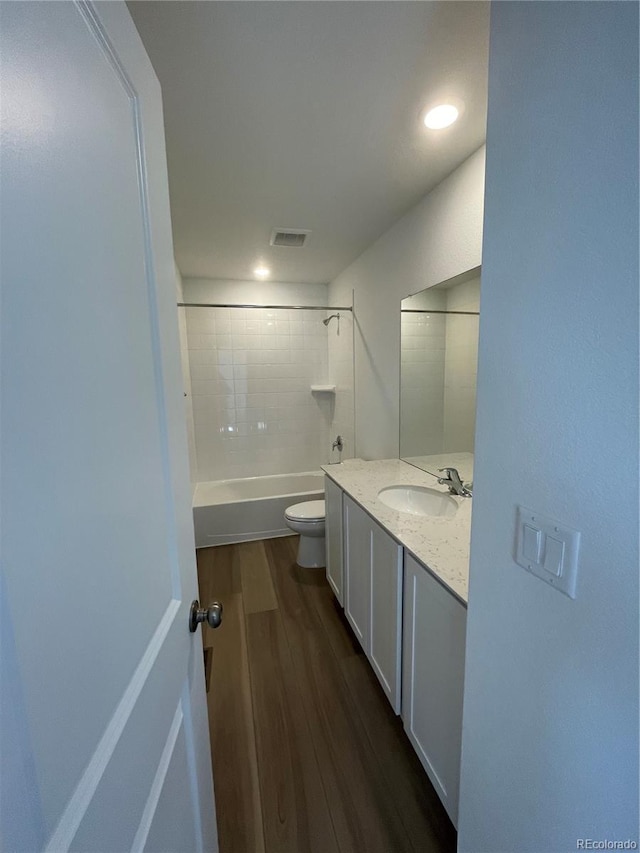 full bathroom featuring vanity, wood finished floors, visible vents, toilet, and shower / bathtub combination