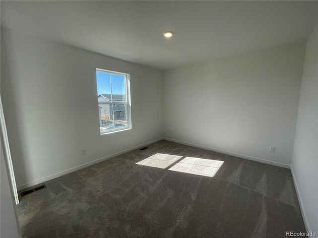 carpeted empty room featuring baseboards and visible vents