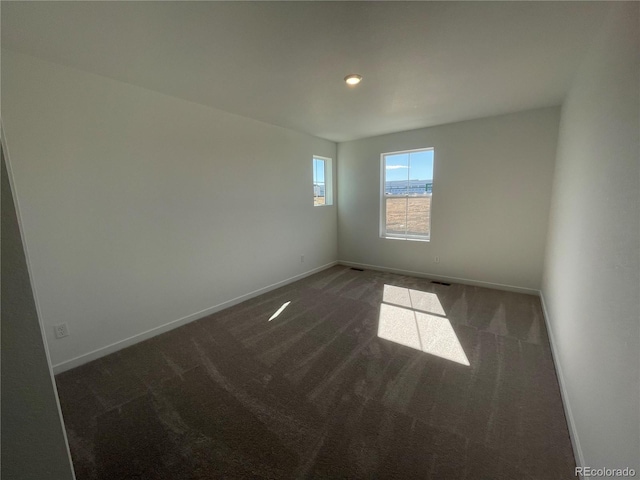 unfurnished room featuring carpet flooring, visible vents, and baseboards