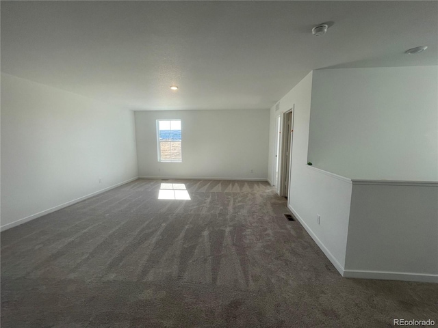 unfurnished room with visible vents, baseboards, and carpet